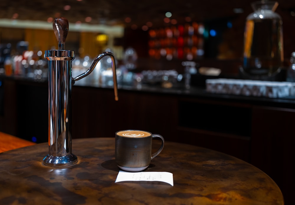 a cup of coffee sitting on top of a wooden table