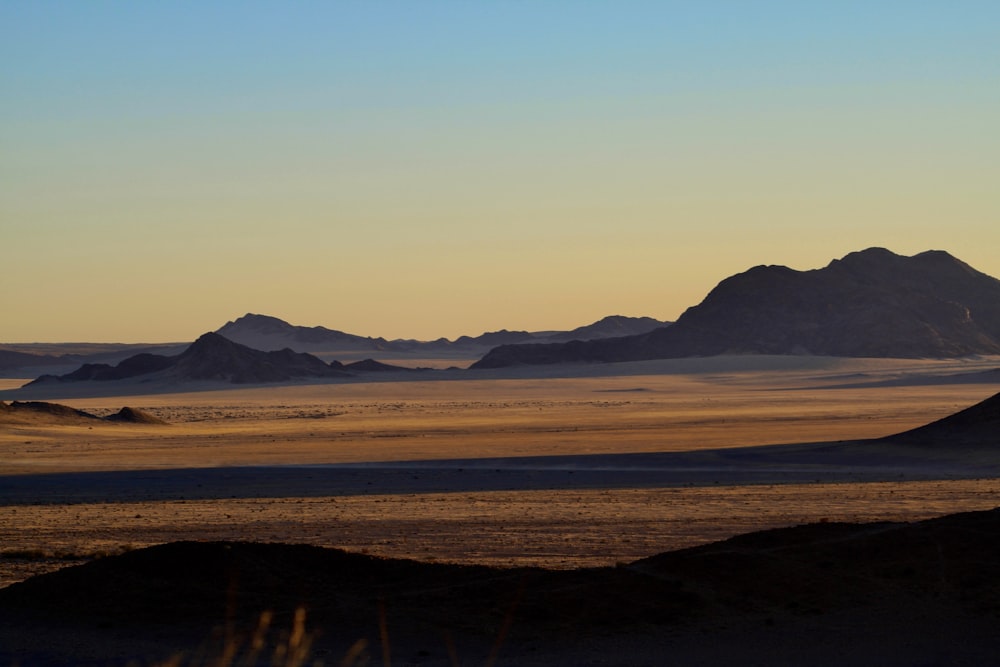 a view of a desert with mountains in the distance