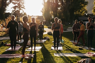 a group of people doing yoga in a park