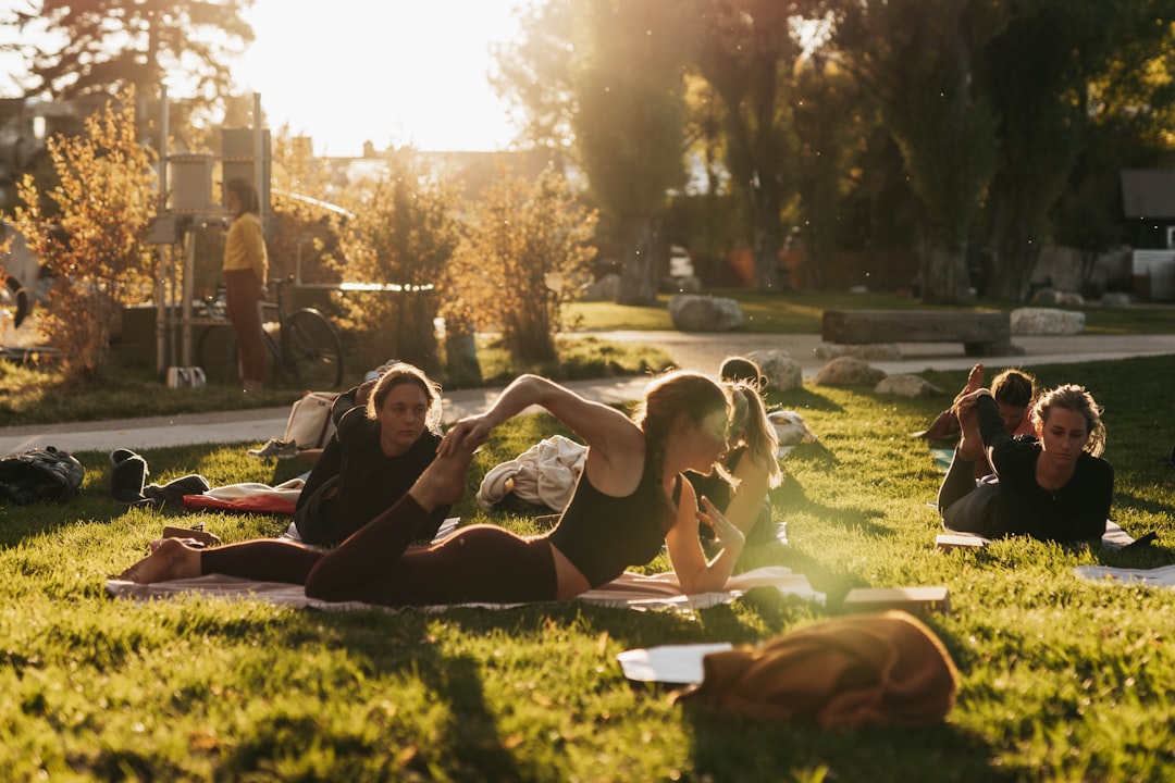 a group of people sitting on top of a lush green field, Embracing inner peace and discovering harmony through the transf