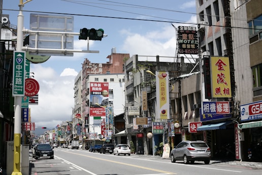 A bustling commercial street lined with diverse retail shops and vibrant signage under a clear sky.