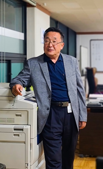 A candid photo of Glen at his desk surrounded by business plans and notes, reflecting his 18 years of entrepreneurial experience.