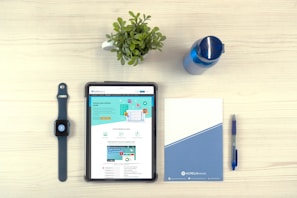 Flat lay of neutral-toned stationery and a tablet showing a goal-tracking Notion dashboard with a spacious, calming design.