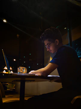 A person working on a laptop with notes and a calm workspace around.