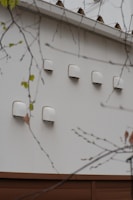 A home exterior with a clean, freshly reattached dryer vent cover in bright sunlight
