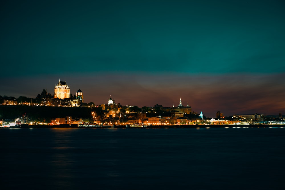 Una vista di una città di notte dall'acqua