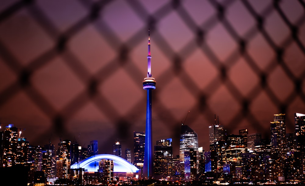 a view of a city skyline through a fence