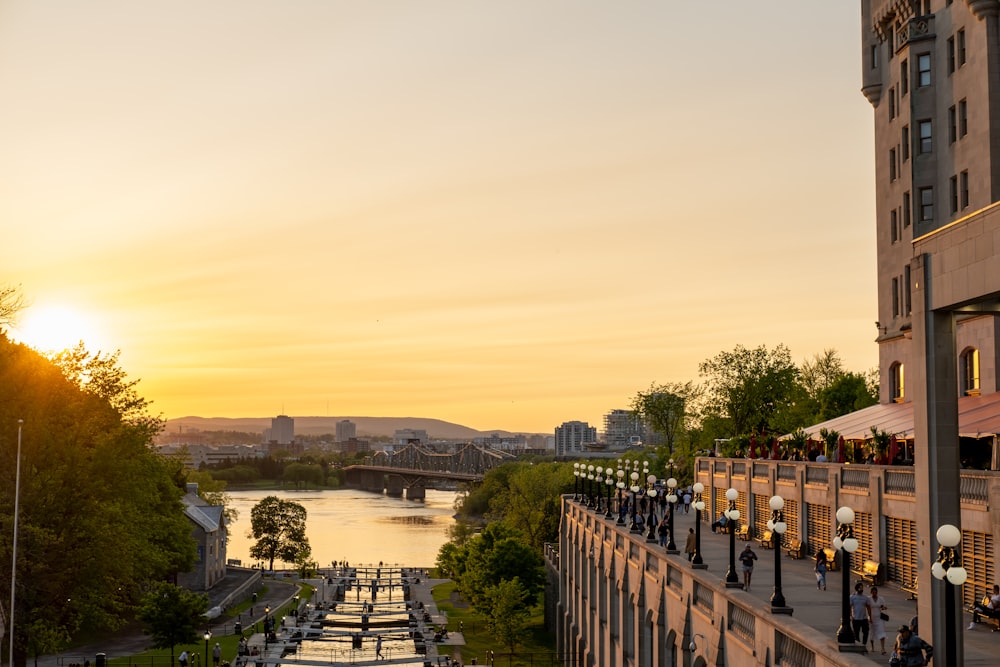 the sun is setting over a river and a bridge