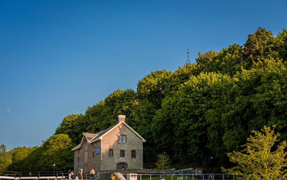 a large brick building sitting next to a lush green forest