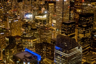 Nighttime aerial shot of a vibrant metropolitan area with illuminated buildings.