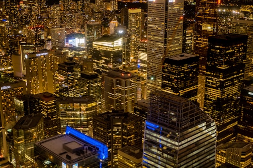 Nighttime aerial shot of a sprawling mixed-use development glowing with lights.