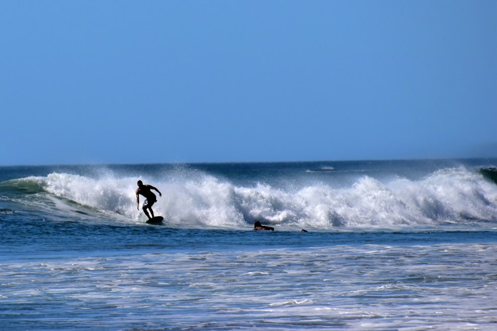 a man riding a wave on top of a surfboard