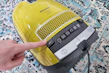 Close-up of a handheld Sweepora vacuum, perfect for quick cleanups on furniture.