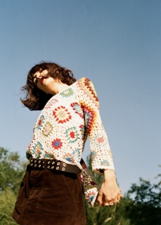 A model showcasing a stylish crochet top in a sunny setting.