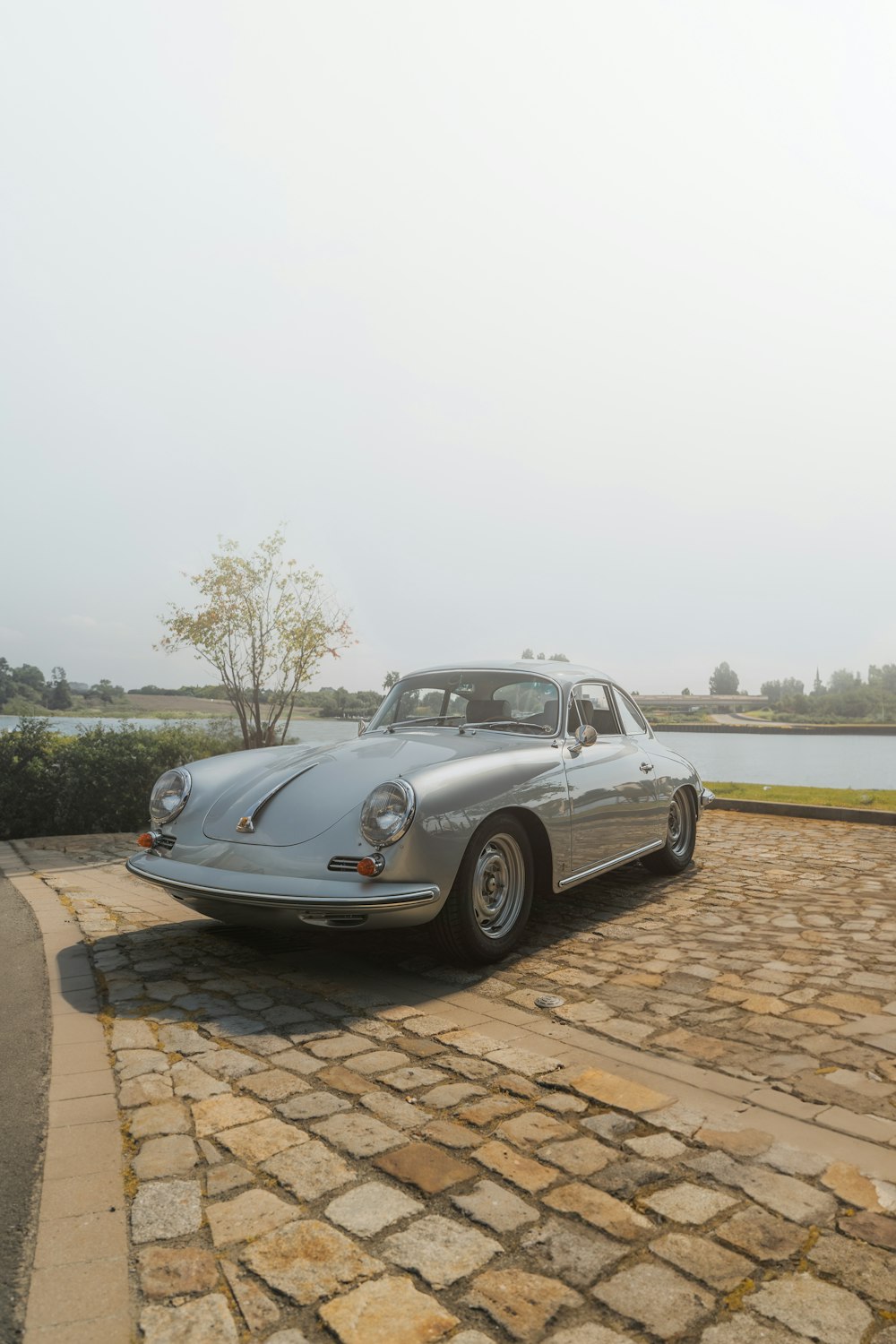 a silver car parked on top of a brick road