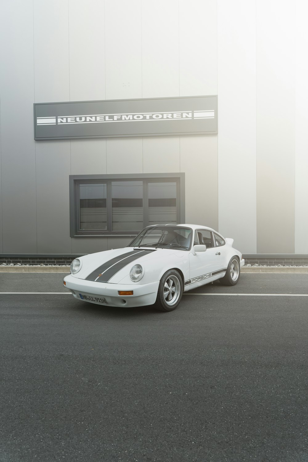 a white porsche parked in front of a building