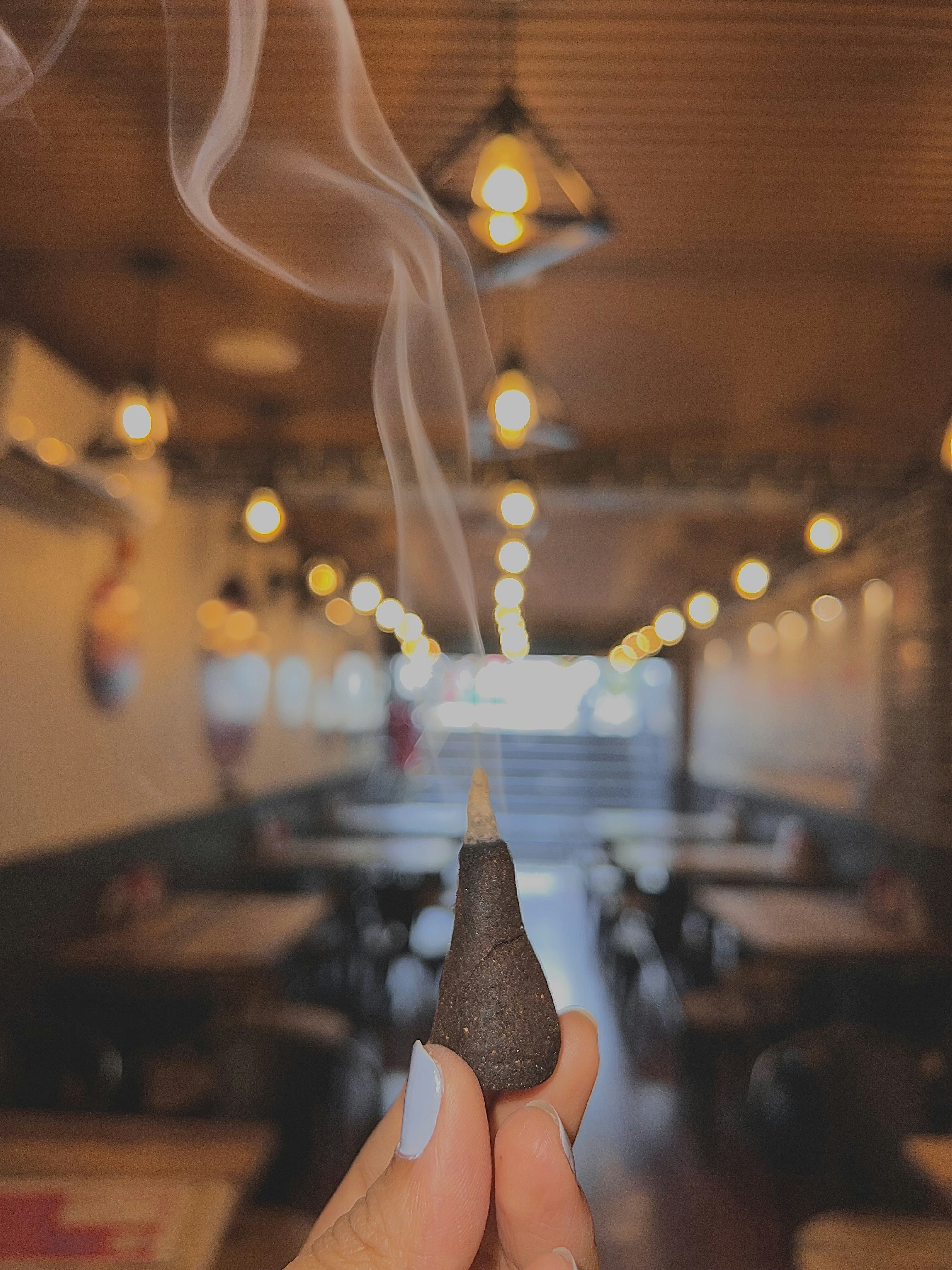 a hand holding a piece of food with smoke coming out of it