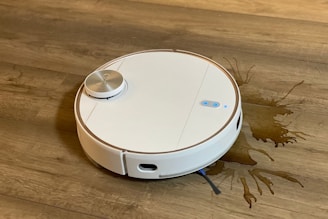 A sleek automatic vacuum cleaner gliding smoothly across a spotless hardwood floor.