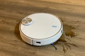 A sleek vacuum cleaner standing ready on a spotless wooden floor.