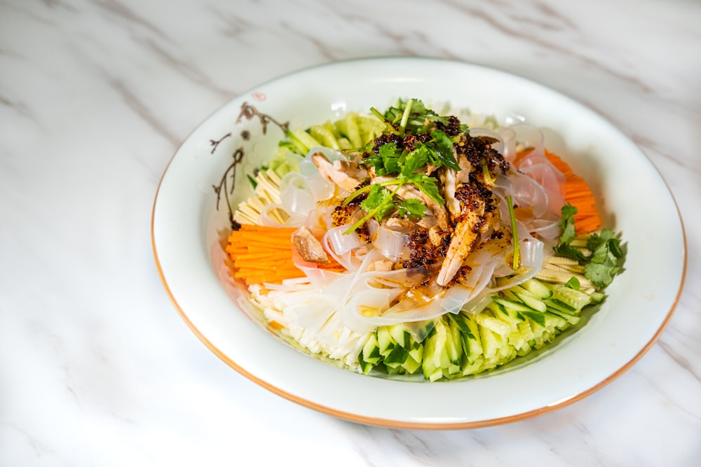 a white plate topped with a salad on top of a table