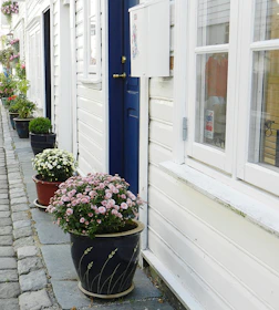 A charming street scene from a village on the Opal Coast with colorful houses and blooming flowers.