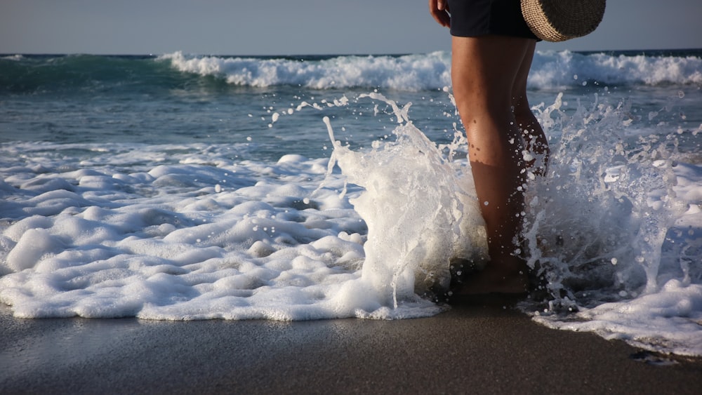 a person standing on a beach next to the ocean