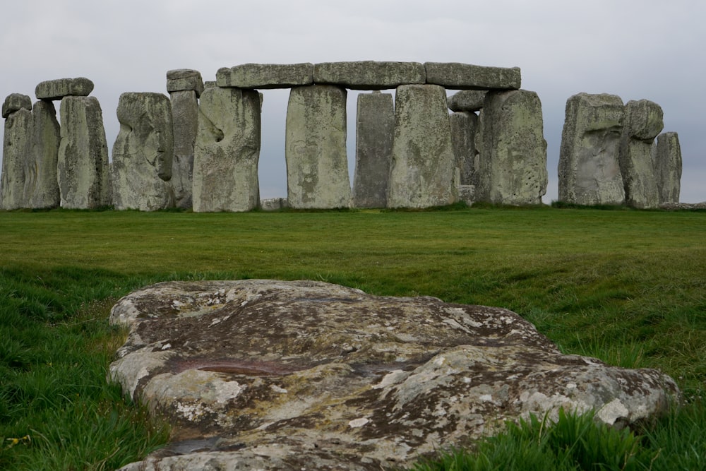 a large stone structure sitting on top of a lush green field