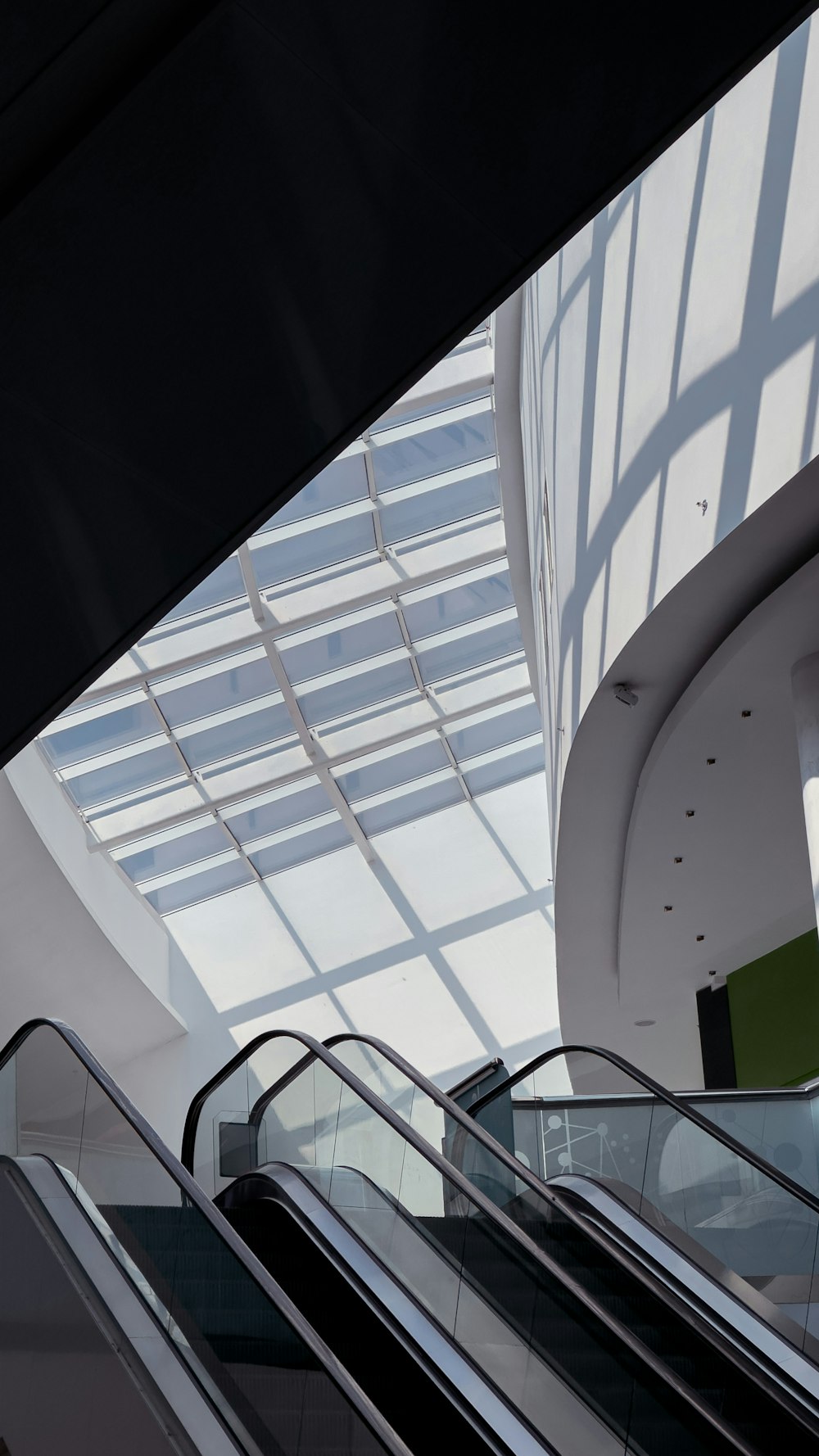 an escalator in a building with a skylight above it