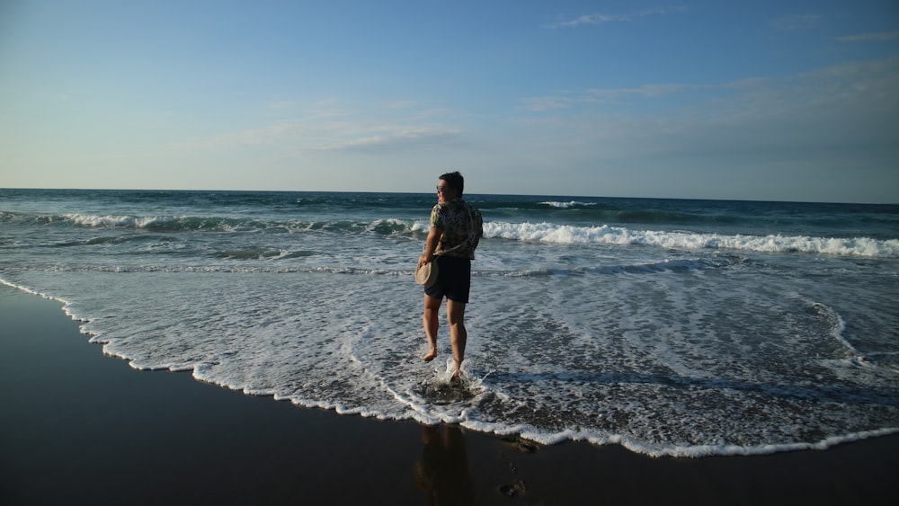 a person standing in the water at the beach