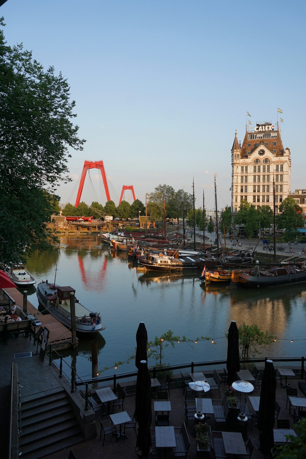 a harbor filled with lots of boats next to a tall building