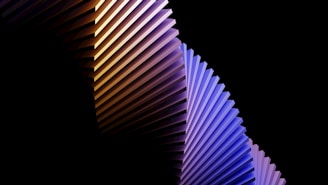 Abstract geometric shapes in orange, green, and blue gradients forming a smooth, modern pattern.