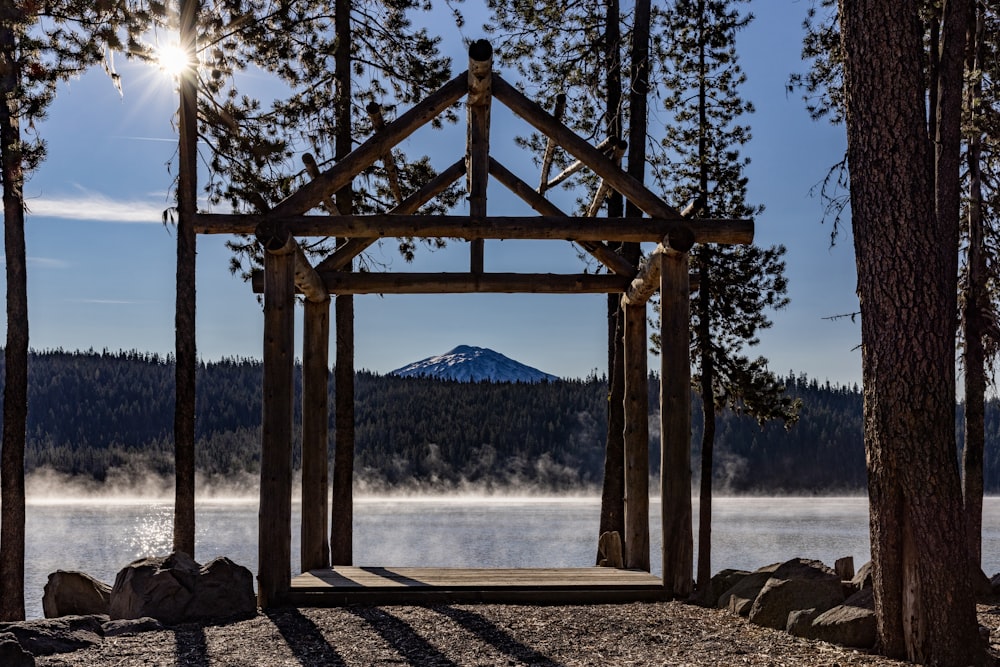 a gazebo surrounded by trees with a mountain in the background