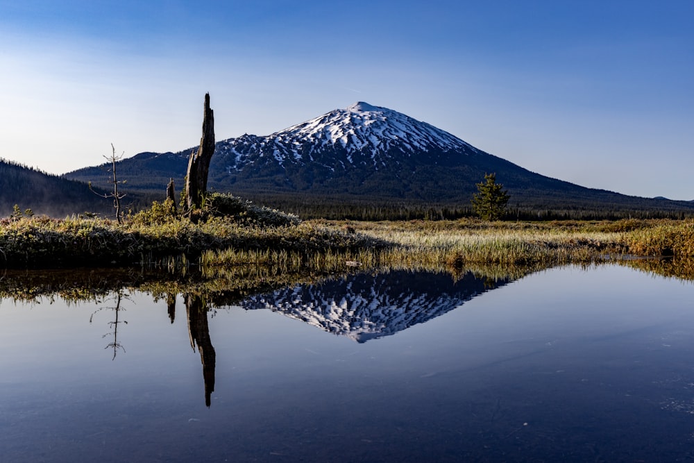 Une montagne se reflète dans l’eau calme d’un lac