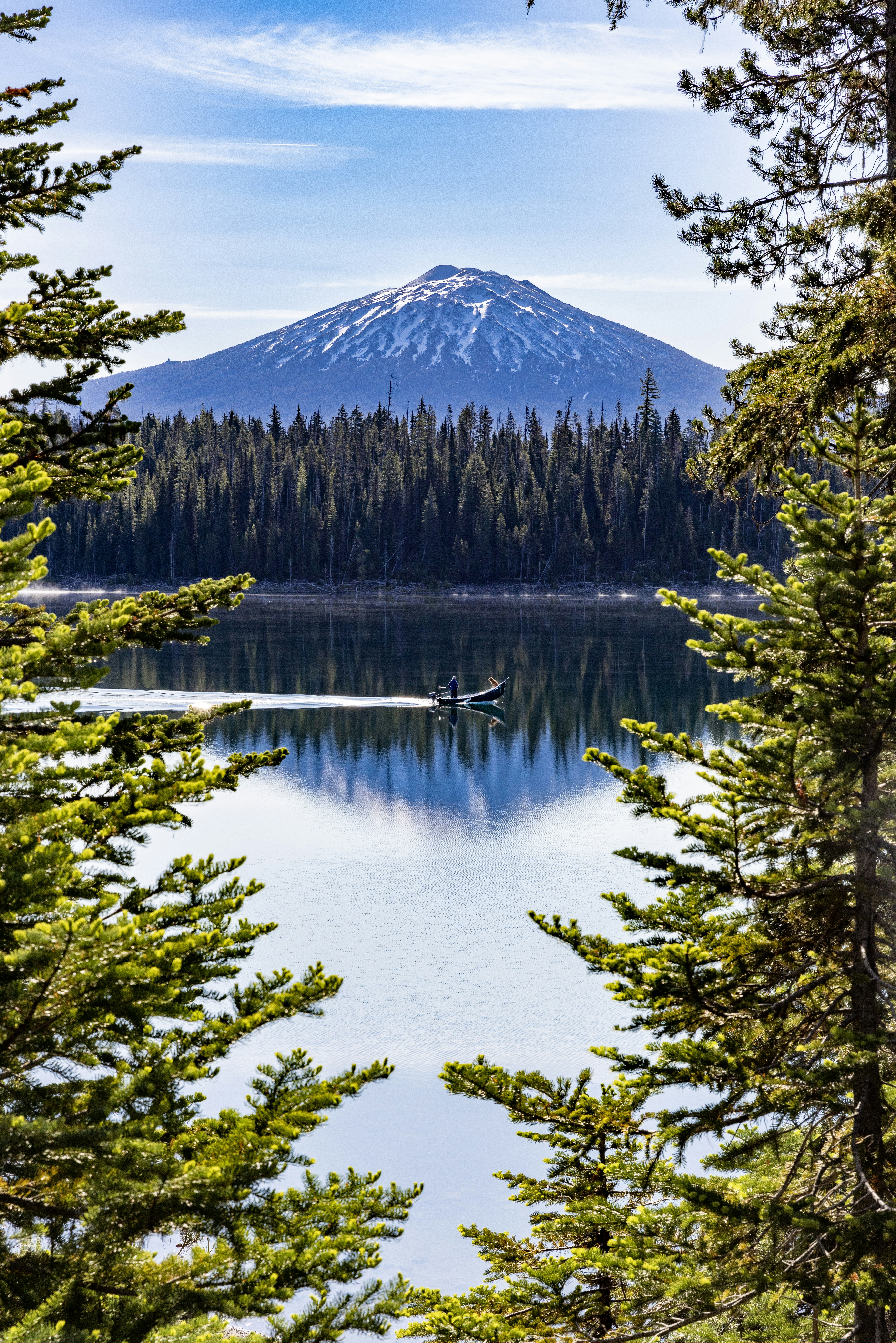 a boat on a lake surrounded by trees