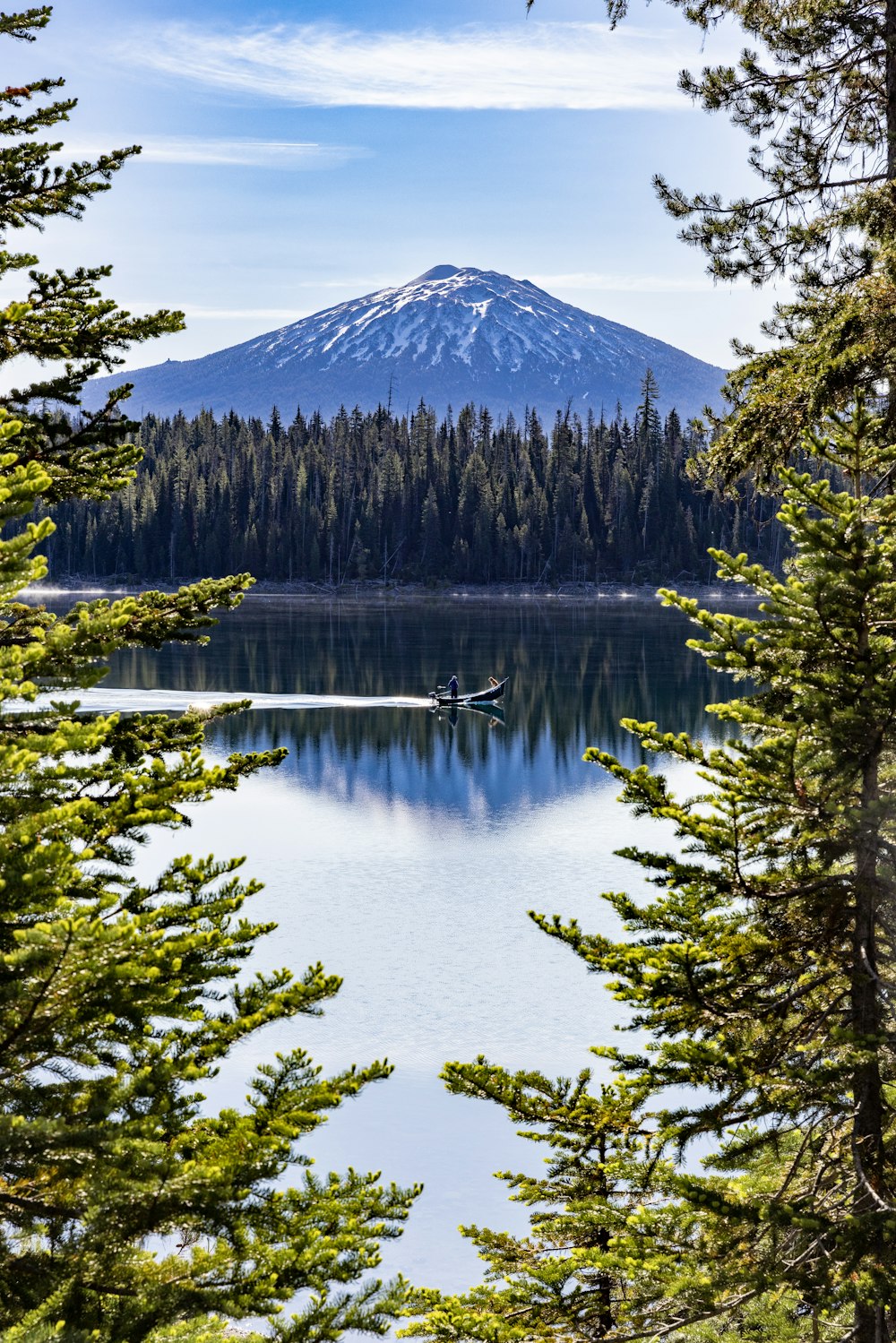 a boat on a lake surrounded by trees