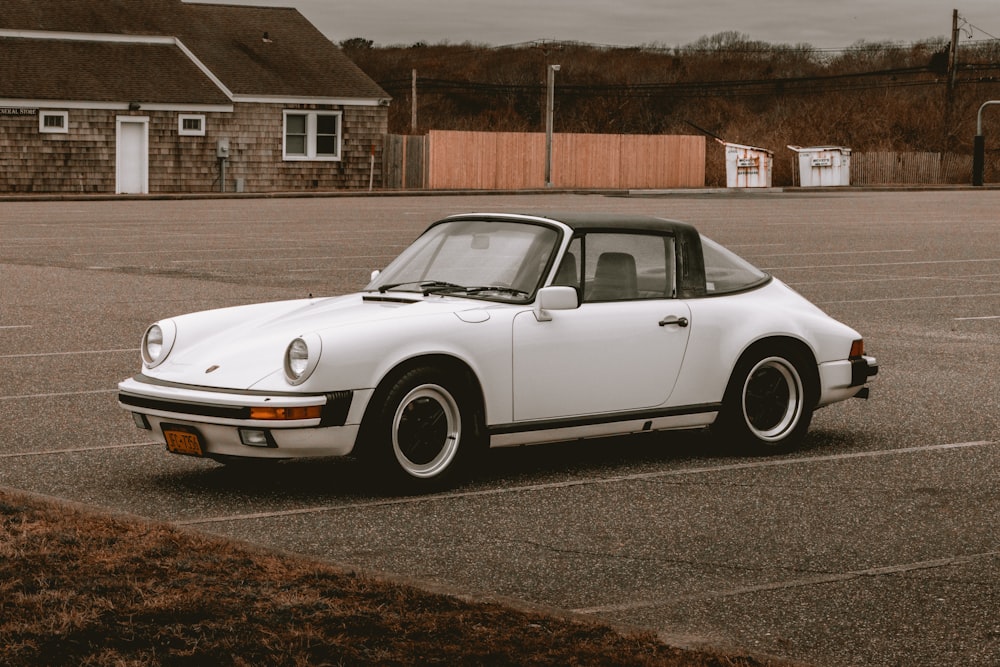 a white porsche parked in a parking lot