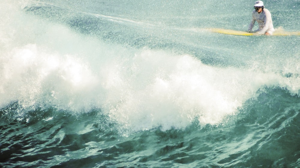 a man riding a wave on top of a surfboard