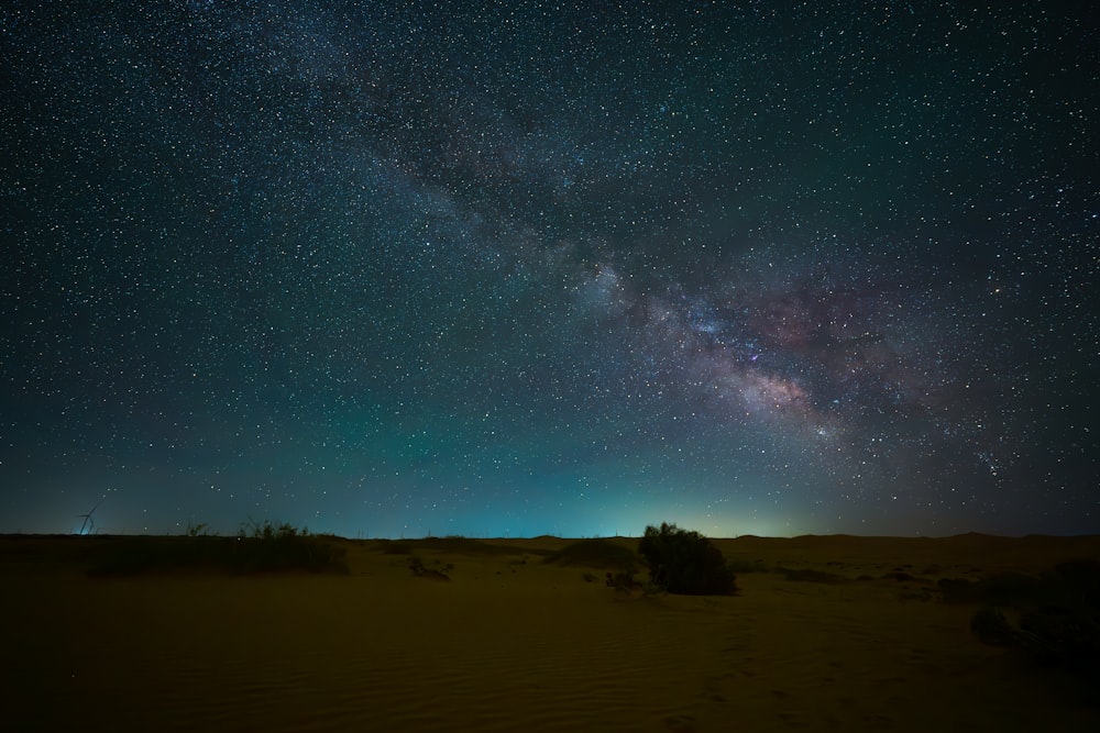the night sky is filled with stars above a desert