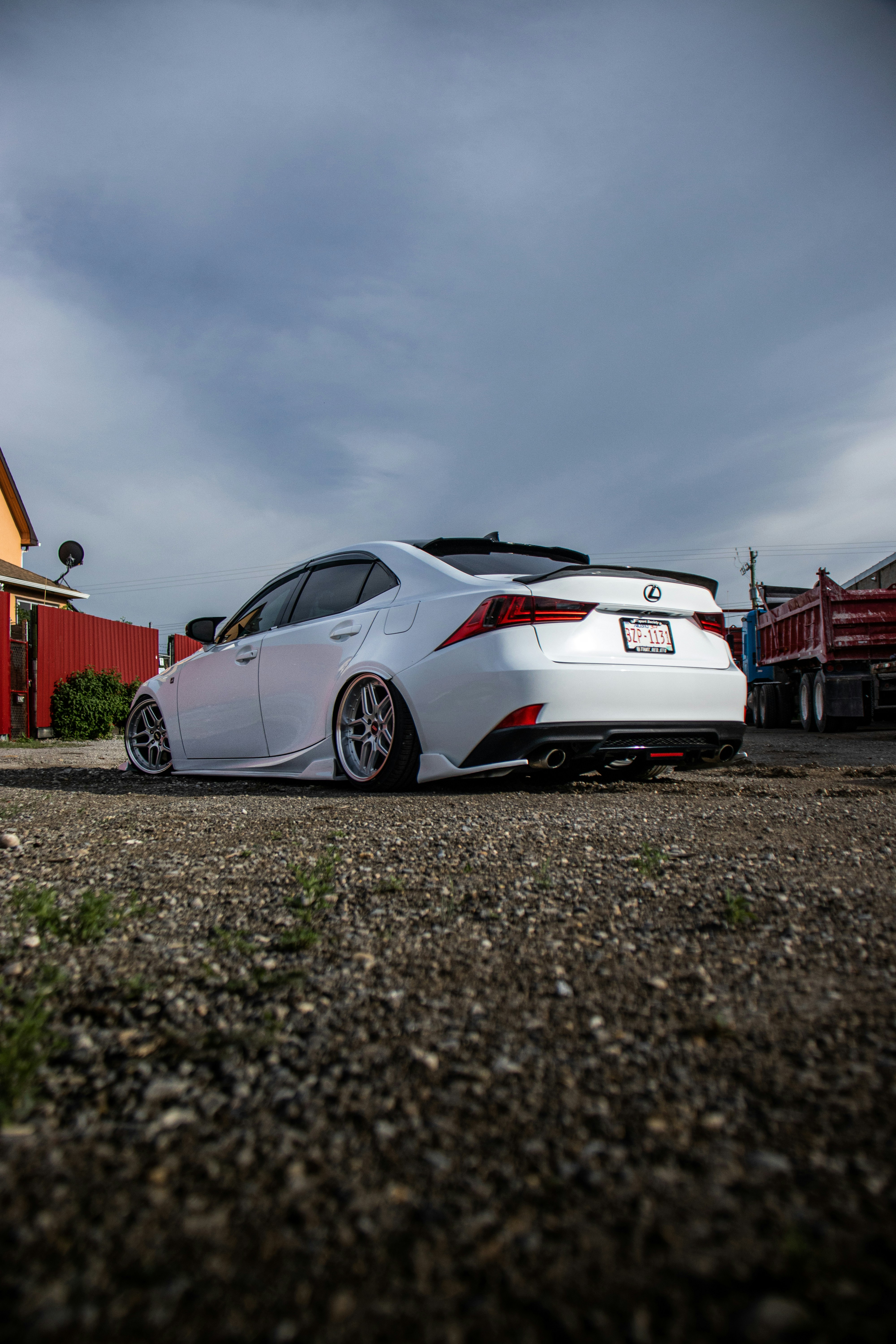 A white car parked in front of a red building photo – Free Car Image on ...