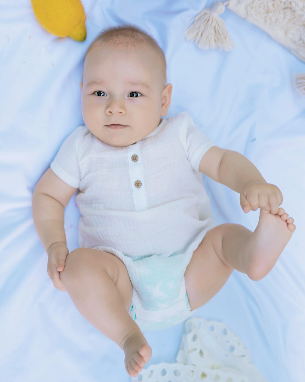 a baby sitting on a bed with a pacifier