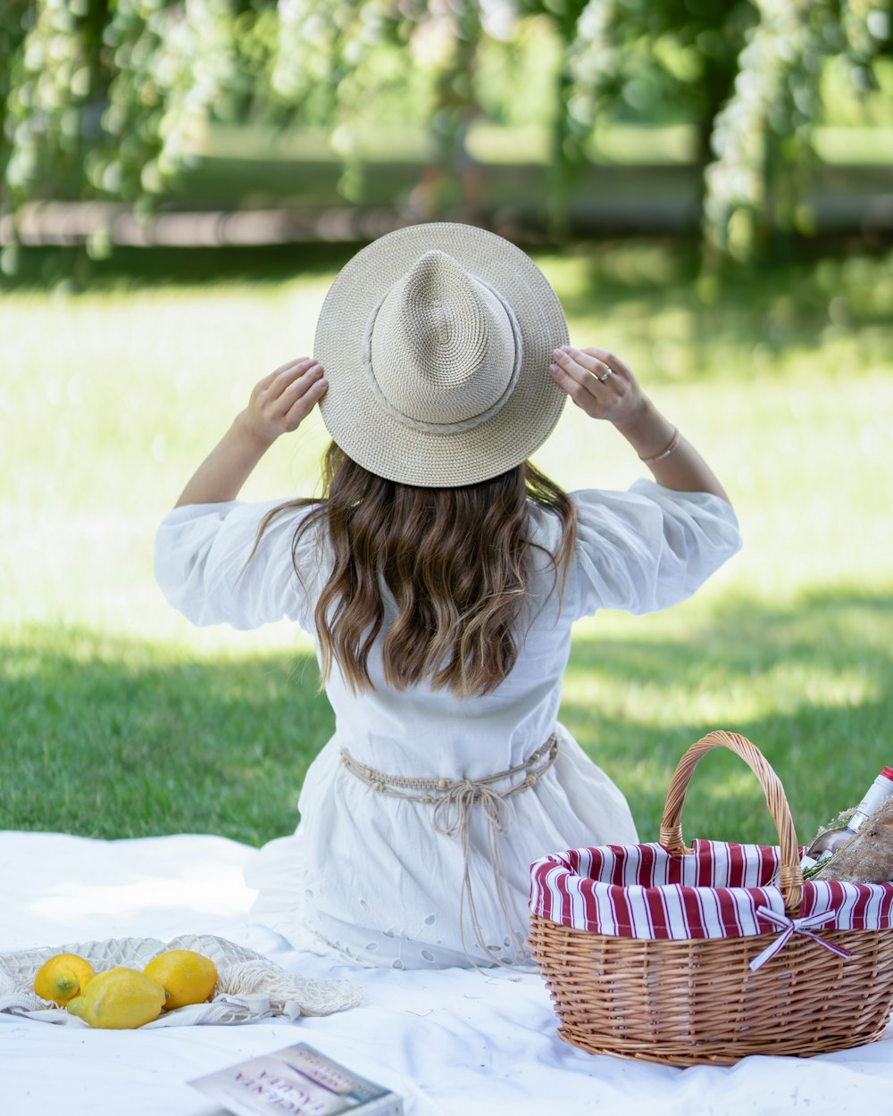 a woman sitting on a blanket with a hat on her head