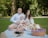 A family enjoying a picnic outdoors with bottles of mineral water on a blanket.