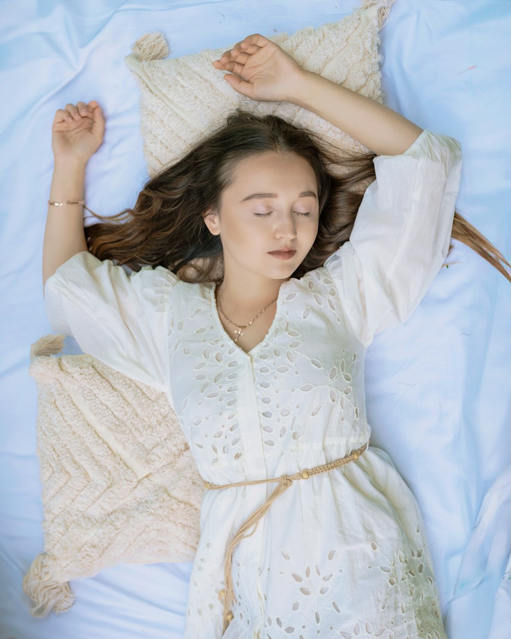 a woman laying on a bed with her eyes closed