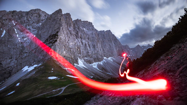 A powerful controlled explosion in a rocky mountainous terrain at dawn.