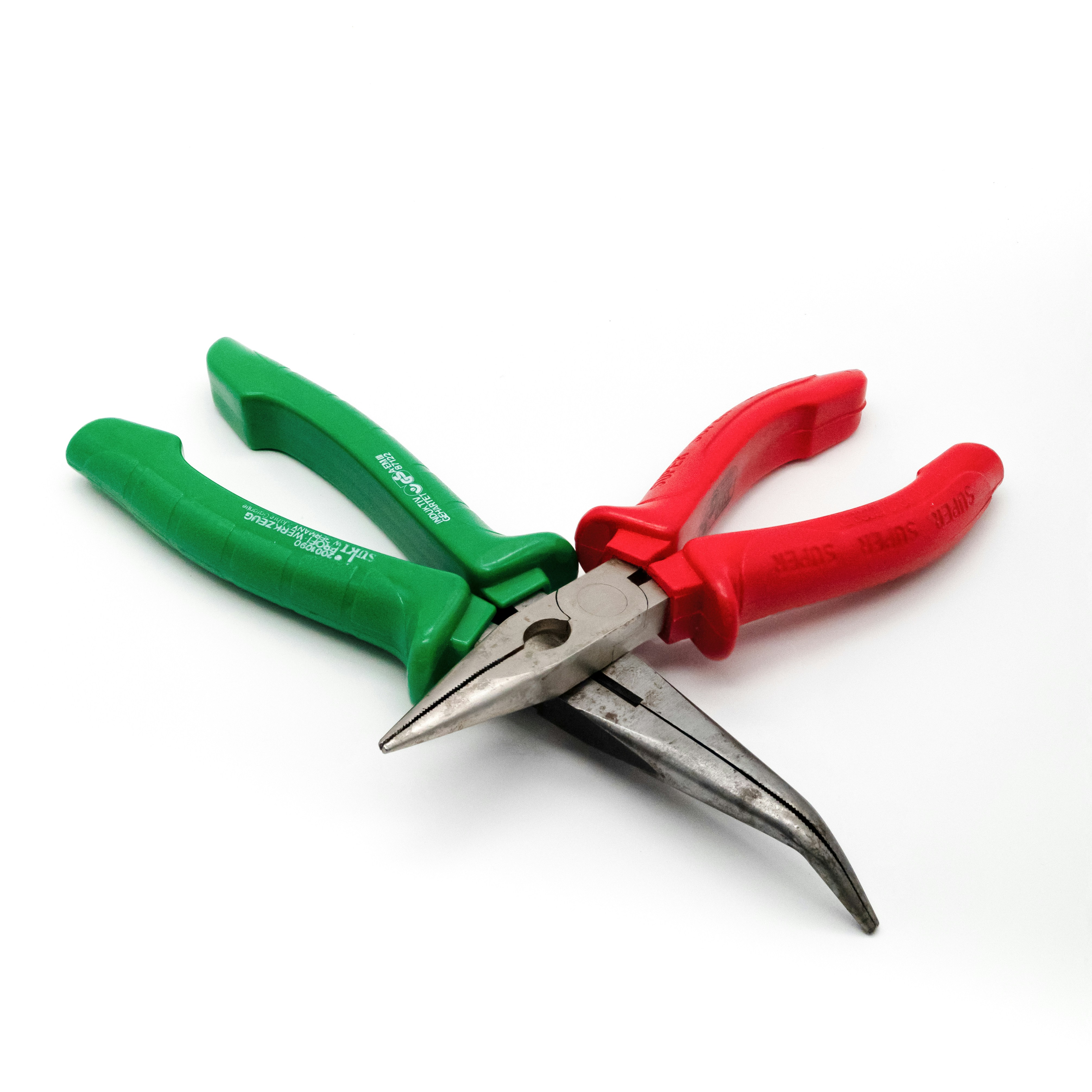 a pair of green and red pliers on a white surface
