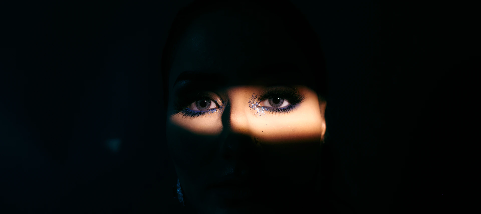 a woman's face is illuminated by the light of a flashlight