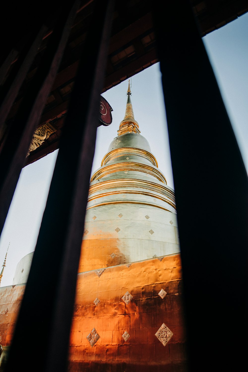 a view of a golden and white pagoda through a window