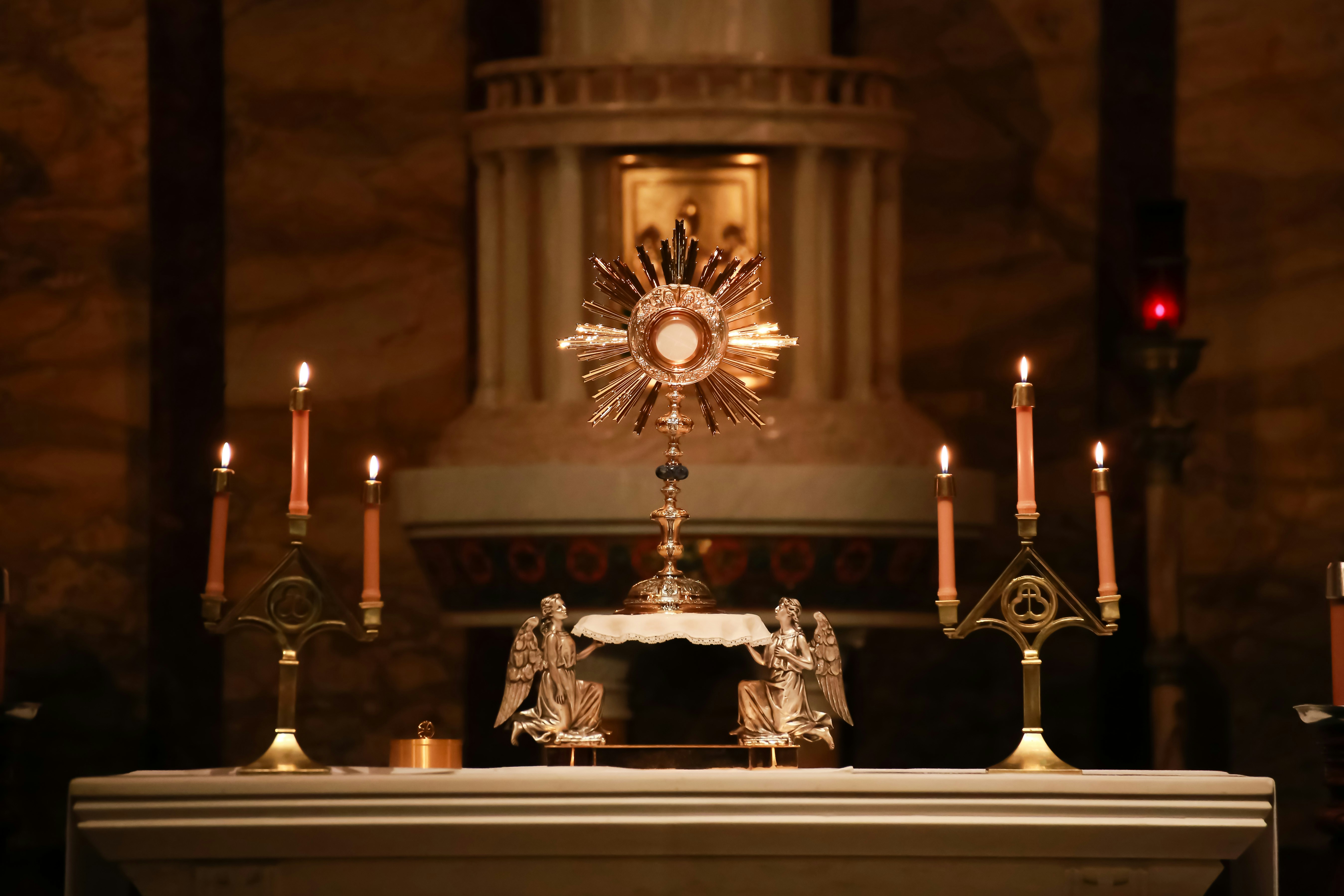 a church alter with candles and a clock on it