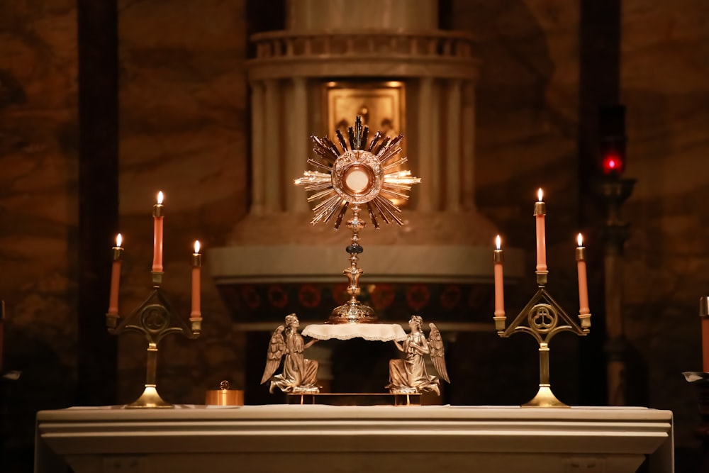 a church alter with candles and a clock on it