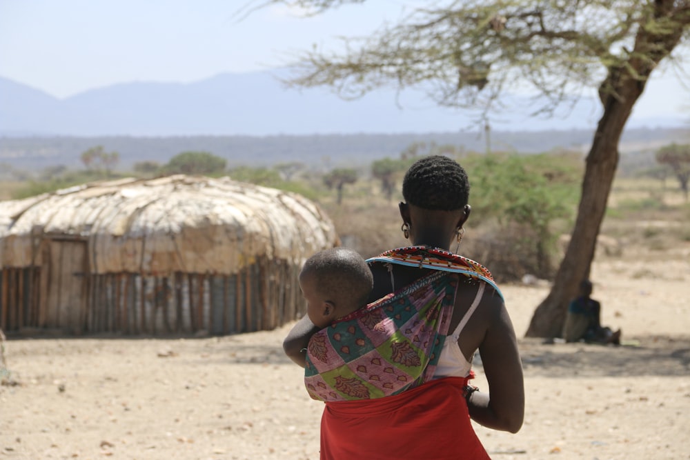 a woman carrying a child on her back